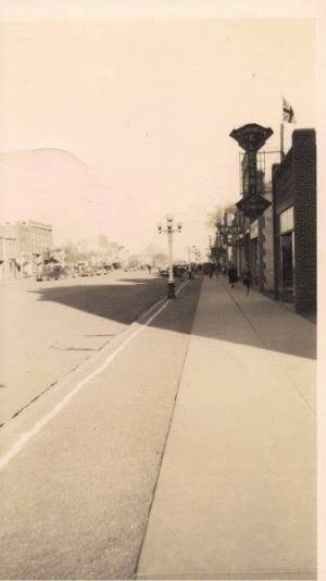 On 4th st taken from 13th ave., Dominion Electric Power Co. First on right, D.L. Irvine Drugs next.  Canada Cafe sign, further down the street. Great White Way lights visible, they were later sold to Brandon MB, Perry Hardware visible on extreme right side. 